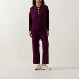 Model wearing Joseph Ribkoff Brushed Knit Track Pants in Elderberry, straight-cut legs, styled with matching purple knit top and cream trainers.