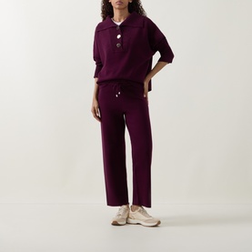 Model wearing Joseph Ribkoff Brushed Knit Track Pants in Elderberry, straight-leg cut with drawstring waist, styled with matching knit polo top.