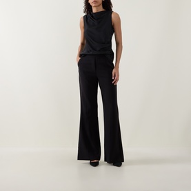 Model wearing Joseph Ribkoff black wide-leg trousers with a black sleeveless cowl-neck top and black heels.