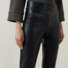 Model wearing Joseph Ribkoff black faux leather trousers with elasticated waistband, styled with a khaki ribbed top.