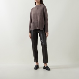 Model wearing Joseph Ribkoff Bonded Faux Leather Trousers in black with straight-cut legs, styled with a taupe knit jumper and black loafers.