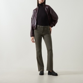 Model wearing Joseph Ribkoff Slim-Leg Jeans in Avocado, styled with a black turtleneck and burgundy leather jacket.