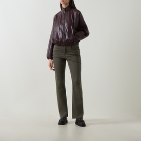 Model wearing Joseph Ribkoff Slim-Leg Jeans in Avocado, styled with a dark burgundy leather bomber jacket and black chunky boots.