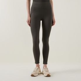 Model wearing Joseph Ribkoff avocado high-waist leggings in nylon-spandex blend, styled with beige trainers