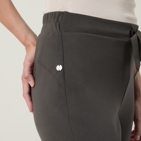 Model wearing Joseph Ribkoff Drawstring Cropped Sweatpants in Avocado, showing elasticated waist, drawstring tie, and silver snap detail.