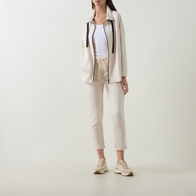 Model wearing Joseph Ribkoff Drawstring Cropped Sweatpants in Birch, styled with a cream zip-up jacket, white top and beige trainers.