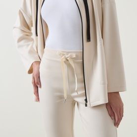 Model wearing Joseph Ribkoff Drawstring Cropped Sweatpants in Birch, styled with a matching zip-up hoodie and white bodysuit.