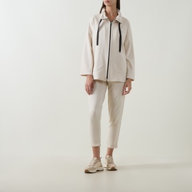 Model wearing Joseph Ribkoff Drawstring Cropped Sweatpants in Birch, styled with a matching zip-up jacket and white trainers.