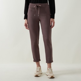 Model wearing Joseph Ribkoff Drawstring Track Pants in Mink with elasticated drawstring waist and rolled cuffs, styled with white trainers