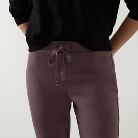 Model wearing Joseph Ribkoff Drawstring Track Pants in Mink, showing satin drawstring waistband detail, styled with black sweatshirt