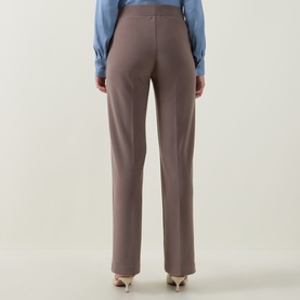Model wearing Joseph Ribkoff Pleated Straight Leg Trousers in Mink, rear view, straight leg silhouette, styled with blue top and gold heels.