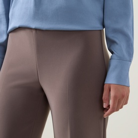 Model wearing Joseph Ribkoff Pleated Straight Leg Trousers in Mink, elasticated waist, styled with a blue top