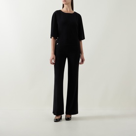 Model wearing Joseph Ribkoff black wide-leg trousers, styled with a matching black batwing top and black heels.