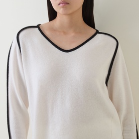 Model wearing Joseph Ribkoff Winter White and Black wool-cashmere tunic with V-neck and contrast black trim detailing.