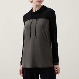 Model wearing Joseph Ribkoff Tunic in Avocado/Black colourblock with hood and drawstring, long sleeves, relaxed fit.