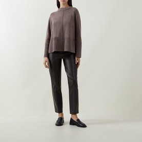 Model wearing Joseph Ribkoff Button Knit Sweater in Mink Melange, high-low hem, styled with black leather trousers and loafers