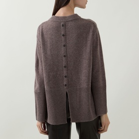 Model wearing Joseph Ribkoff Button Knit Sweater in Mink Melange, showing back button detail, ribbed trims and split hem, styled with black trousers.