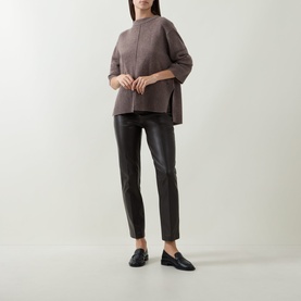 Model wearing Joseph Ribkoff Button Knit Sweater in Mink Melange, high-low hem, styled with black leather trousers and loafers