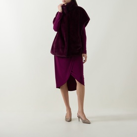 Model wearing Joseph Ribkoff Elderberry faux fur vest over matching purple midi skirt, styled with nude slingback heels