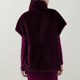 Model wearing Joseph Ribkoff Elderberry faux fur vest, back view, styled with matching purple midi skirt