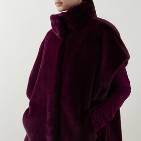 Model wearing Joseph Ribkoff Elderberry faux fur vest with high neck and oversized silhouette, styled with long-sleeve top underneath