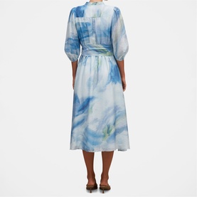 Model wearing Forever New midi dress in Bluewater Abstract print, puff sleeves, belted waist, back view, styled with brown heeled mules.
