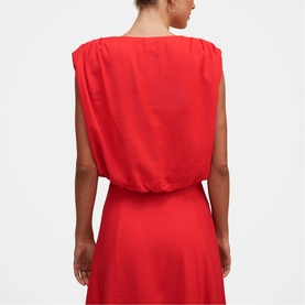 Model wearing Forever New dress in Cherry Tomato, sleeveless with elasticated waist, back view showing draped neckline detail.