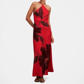 Model wearing Forever New red maxi dress with large black floral print, halterneck crossover neckline and flared hem.