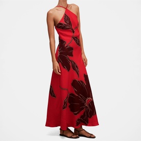 Model wearing Forever New Red Dryden maxi dress with large floral print, asymmetric halter neckline and A-line skirt, styled with flat sandals.