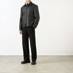 Model wearing Prada black nappa leather casual jacket with zip front, styled with black trousers and leather loafers.
