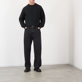 Model wearing Prada Logo Raglan Sweatshirt in black with boxy fit, styled with black wide-leg jeans and black loafers.