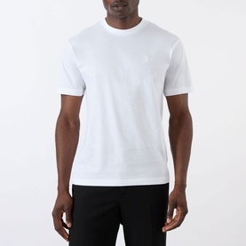Model wearing Prada white cotton crew-neck T-shirt with small logo embroidery, styled with black trousers.
