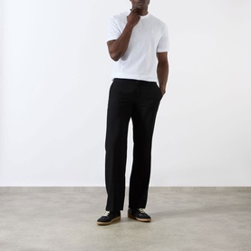 Model wearing Prada white cotton T-shirt, styled with black straight-leg trousers and black trainers.