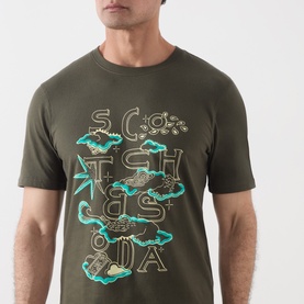 Model wearing Scotch & Soda Forest Night green cotton T-shirt with turquoise and gold branded graphic print on chest