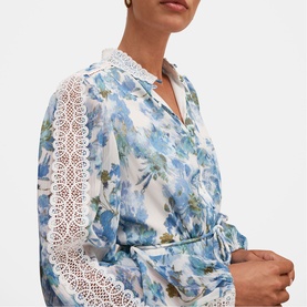 Model wearing Forever New Dangar Floral dress with lace sleeve inserts and collar detail, wrap-style silhouette in blue floral print