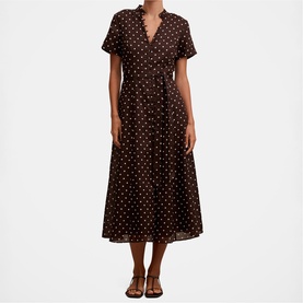 Model wearing brown polka dot short-sleeve midi dress with V-neckline and flared skirt, styled with tan strappy sandals