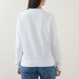 Model wearing Tommy Heritage Logo Sweatshirt in ecru, crew neck, long sleeves, ribbed trims, back view, styled with blue jeans
