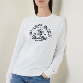 Model wearing Tommy Heritage Logo Sweatshirt in ecru with navy crew neck, long sleeves, ribbed trims and contrast Heritage Sports Club logo graphic.