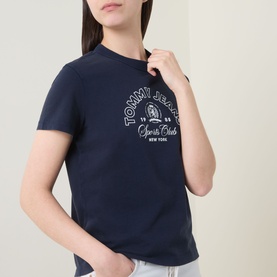 Model wearing Tommy Heritage Logo T-Shirt in Dark Night Navy with crew neck, short sleeves, and contrast Heritage Sports Club graphic print on chest.