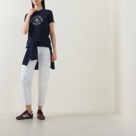 Model wearing Tommy Heritage Logo T-Shirt in Dark Night Navy with white cropped jeans and burgundy trainers