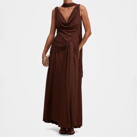 Model wearing Forever New dark mahogany maxi dress with cowl neck, sleeveless design and ruched waist detail, styled with a small clutch bag