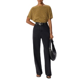 Model wearing Whistles green polka dot short-sleeve top with black wide-leg jeans and belt, carrying a black shoulder bag