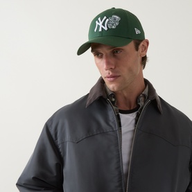 Model with New Era New York Yankees MLB Food Icon 9FORTY Baseball Cap in green, curved visor, embroidered logo, styled with grey jacket
