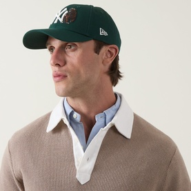 Model with New Era New York Yankees MLB Outdoor Icon 9FORTY Baseball Cap in dark green, embroidered bear logo, curved visor, worn with knit jumper