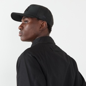 Model with New Era New York Yankees MLB 9FORTY Apex Baseball Cap in black, curved visor, structured crown, worn with black jacket