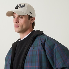 Model with New Era LA Dodgers MLB Outdoor Icon 9FORTY Baseball Cap in beige, embroidered eagle logo, curved visor, styled with plaid jacket