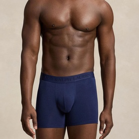 Model wearing navy blue fitted boxer briefs with branded elastic waistband, cropped torso shot against neutral background