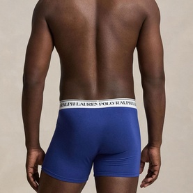 Model wearing blue Polo Ralph Lauren trunks with white branded waistband, shown from behind