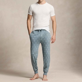 Model wearing grey joggers with all-over pony print, styled with a white crew-neck T-shirt