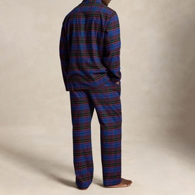 Model wearing blue, red and brown tartan plaid pyjama set with long-sleeve top and matching straight-leg trousers, back view
